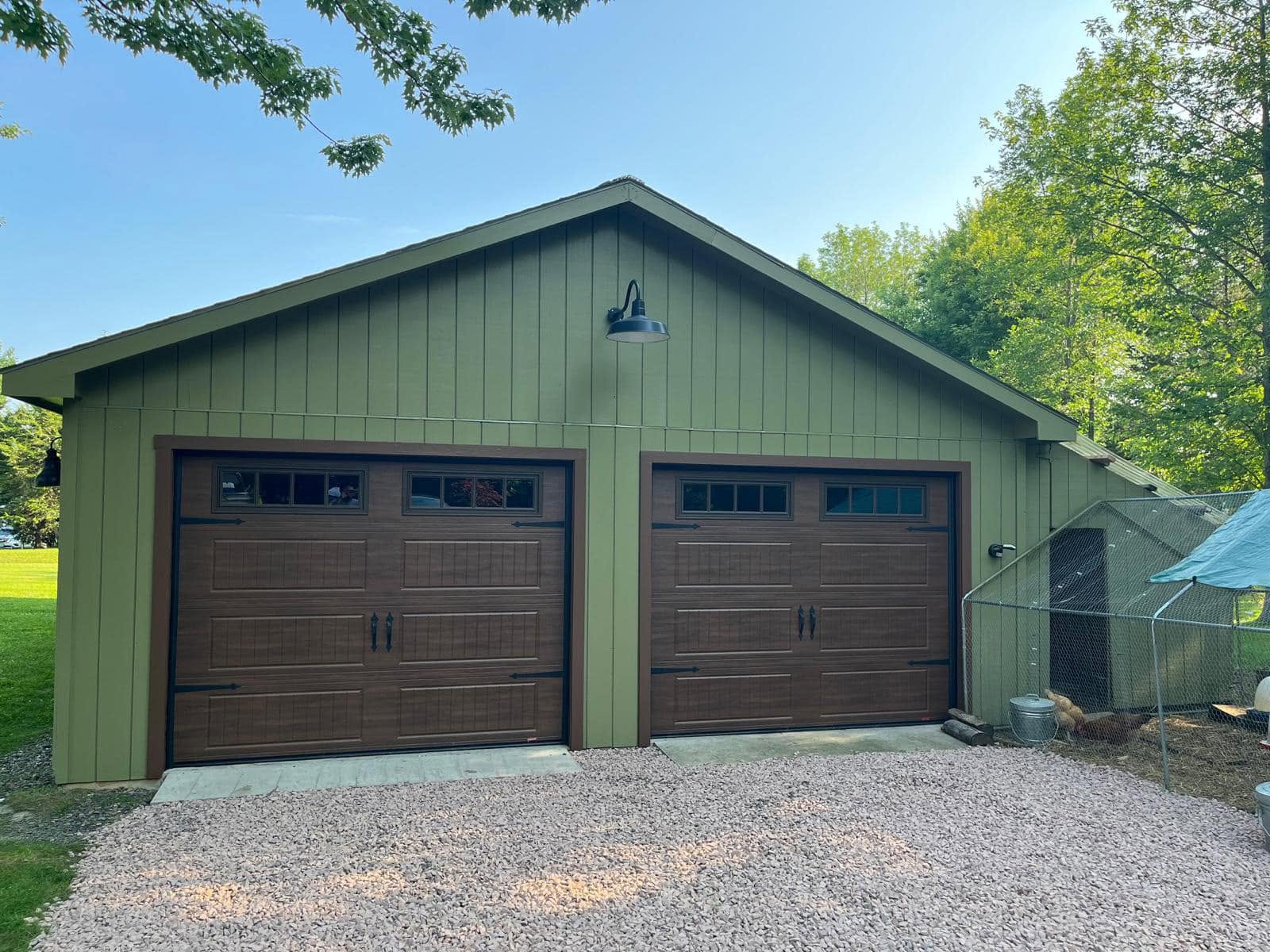 Green garage exterior with wood doors
